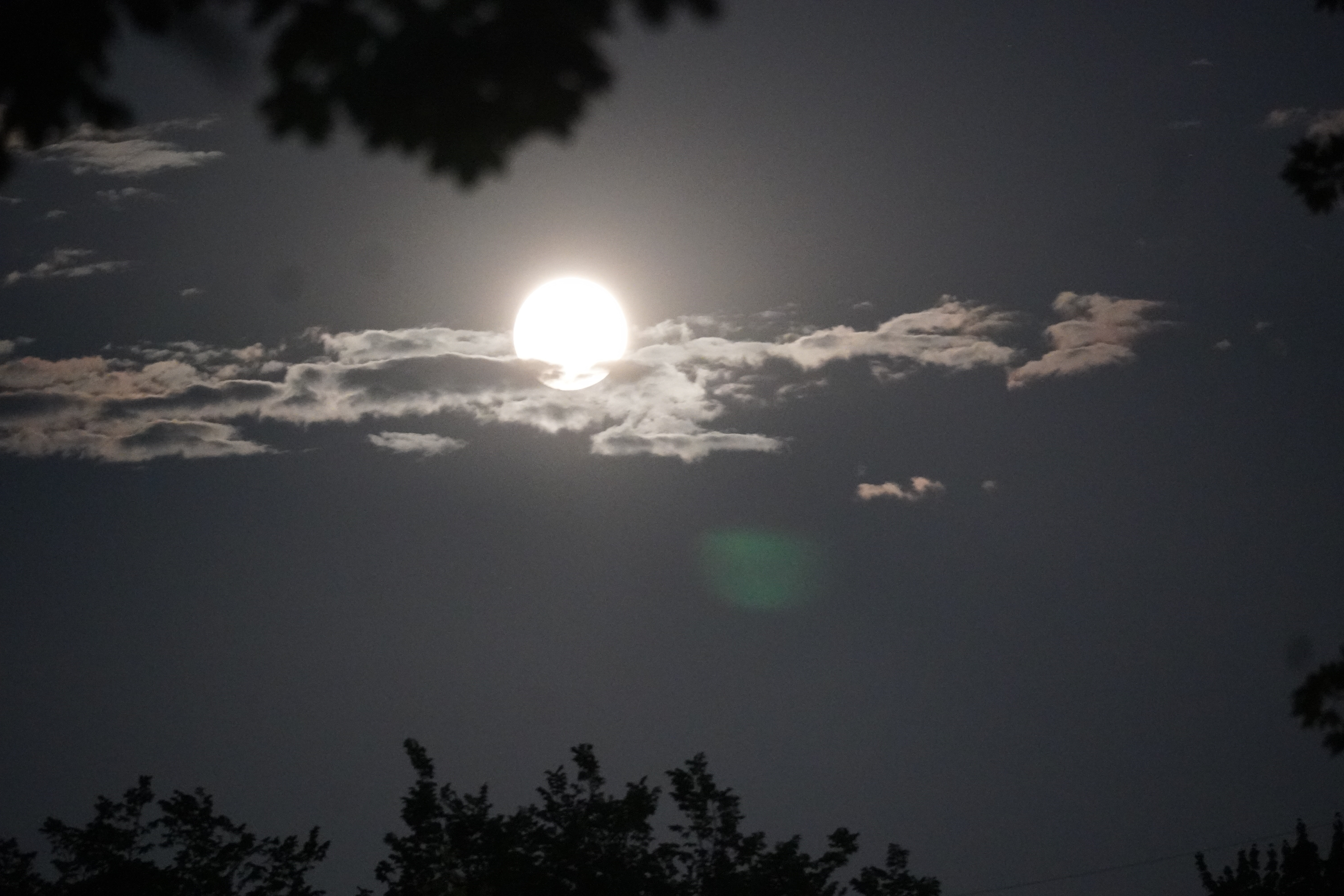 Moon behind wispy clouds